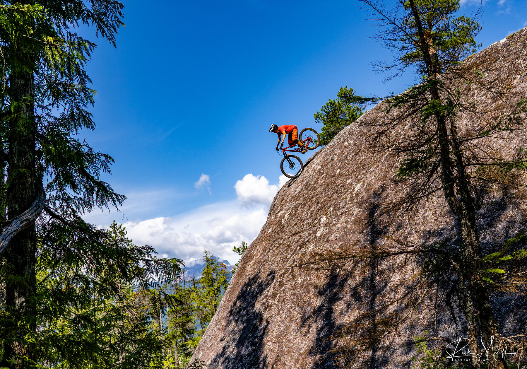 Rider dropping down a steep granite slab